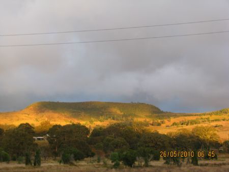 sunrise hits the hill across the valley
